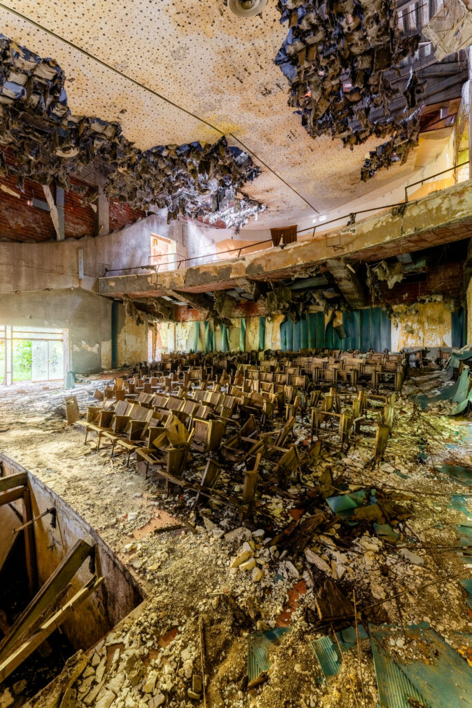 Intérieur d'un théâtre abandonné avec des sièges en ruine