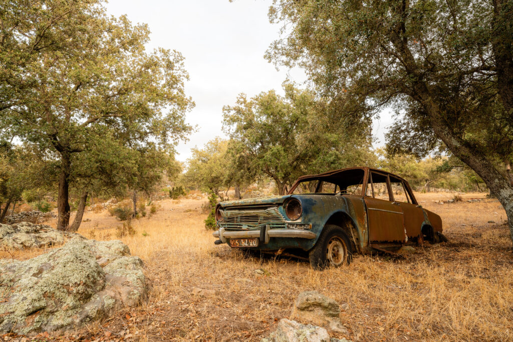 Vieille voiture abandonnée dans un champ sec