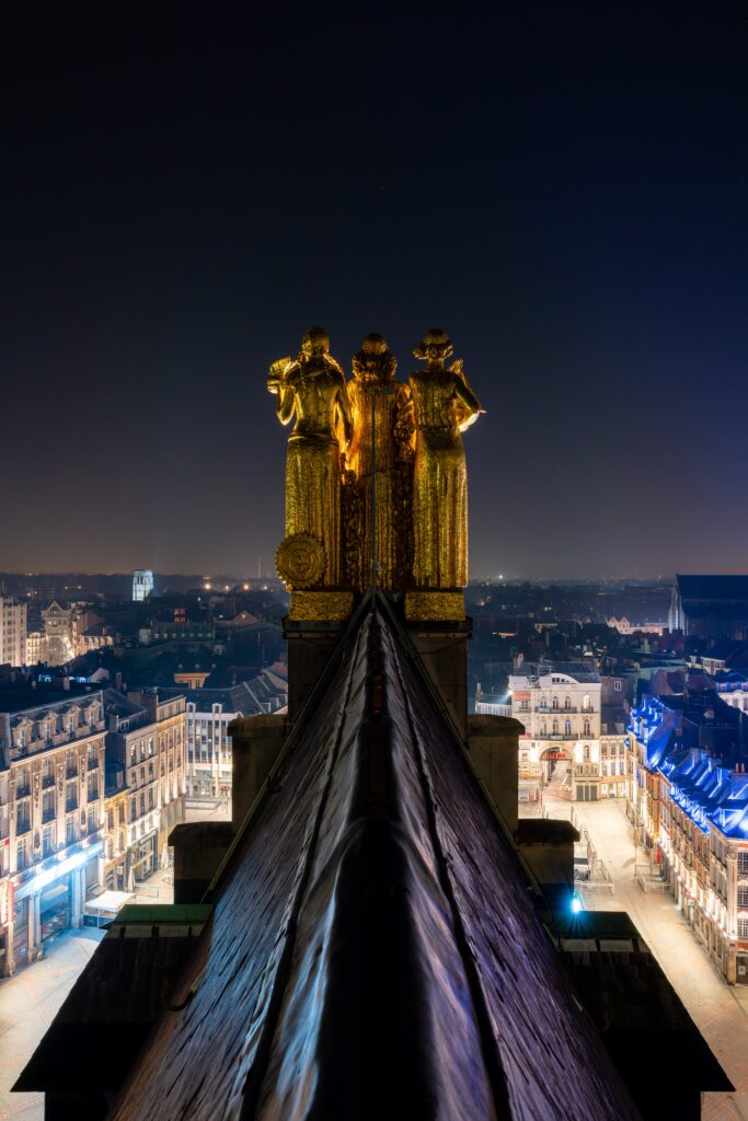 Statues dorées surplombant la ville illuminée la nuit