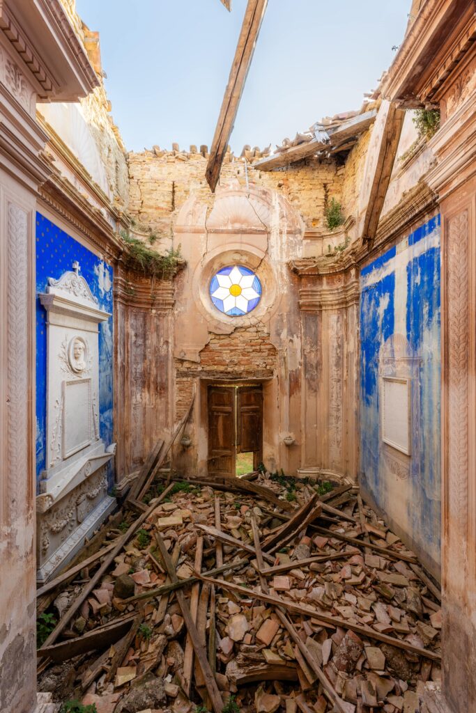 Intérieur d'une église en ruine avec fresques et toit effondré